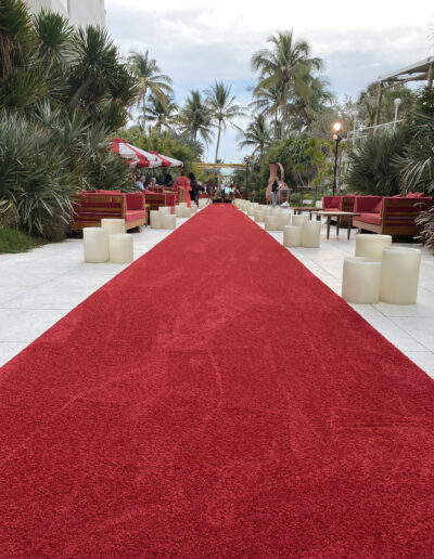 Long red carpet runway installation for a luxury outdoor event at a coastal venue