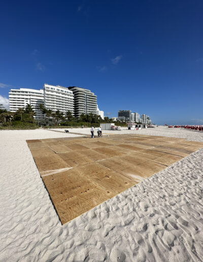 Plywood subfloor platform installation on a beach for a large outdoor event