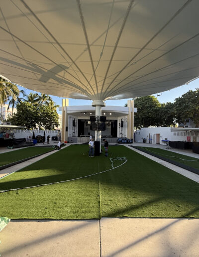 Outdoor synthetic turf carpet installation under a large pavilion structure