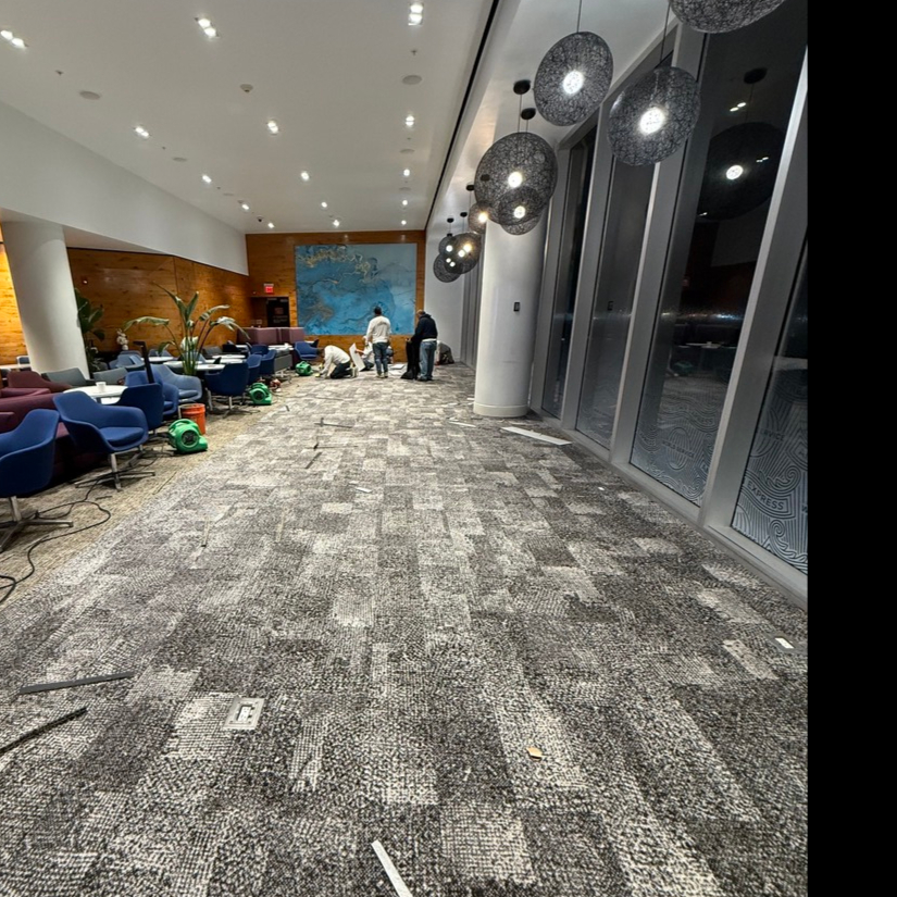 Large-scale commercial carpet tile installation featuring textured gray geometric patterns in an airport lounge.